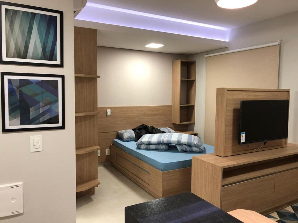 a room with a bed and a flat screen tv at Flat novinho e completo in Sao Jose do Rio Preto