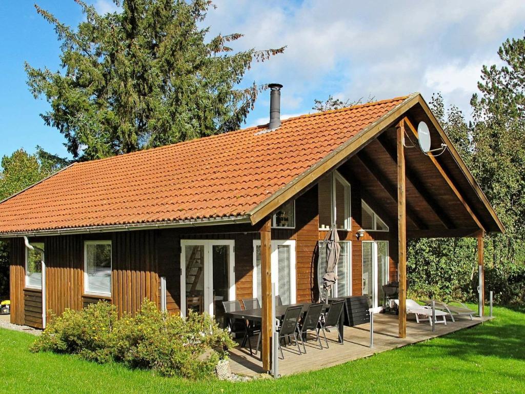 スタイにある8 person holiday home in Stegeのオレンジの屋根と椅子のある庭