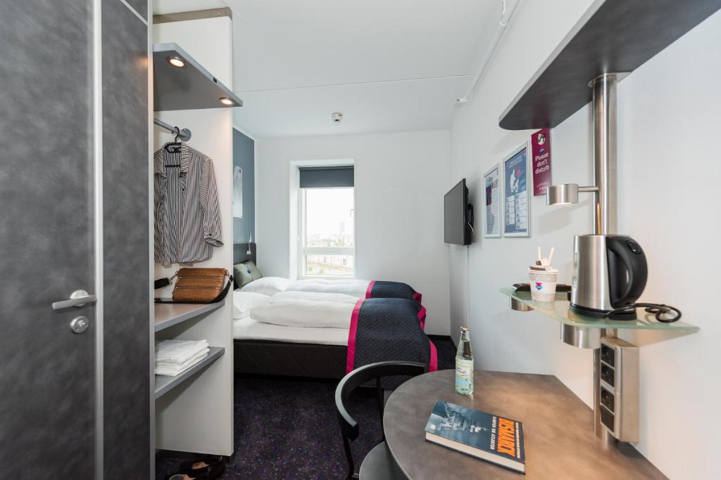 a small room with a bed and a table at Cabinn Copenhagen in Copenhagen