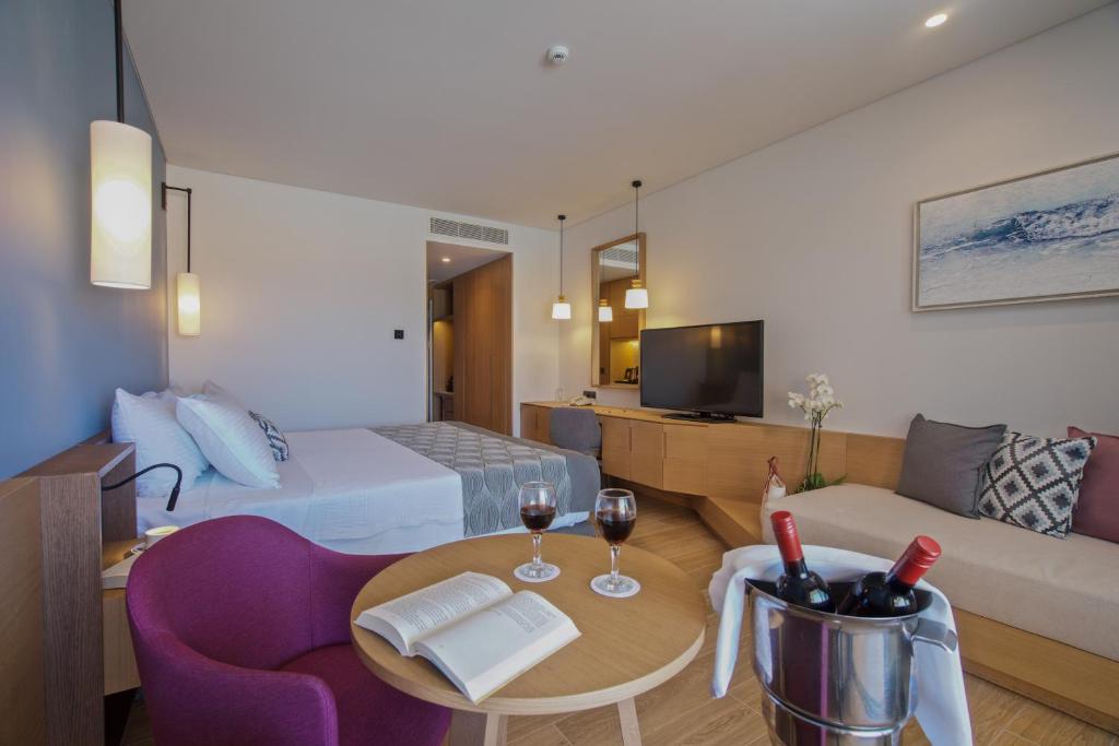 A television and/or entertainment centre at Apollonion Asterias Resort and Spa