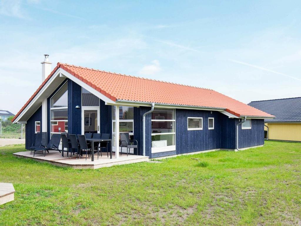 una casa azul con techo rojo en 8 person holiday home in Gro enbrode, en Großenbrode