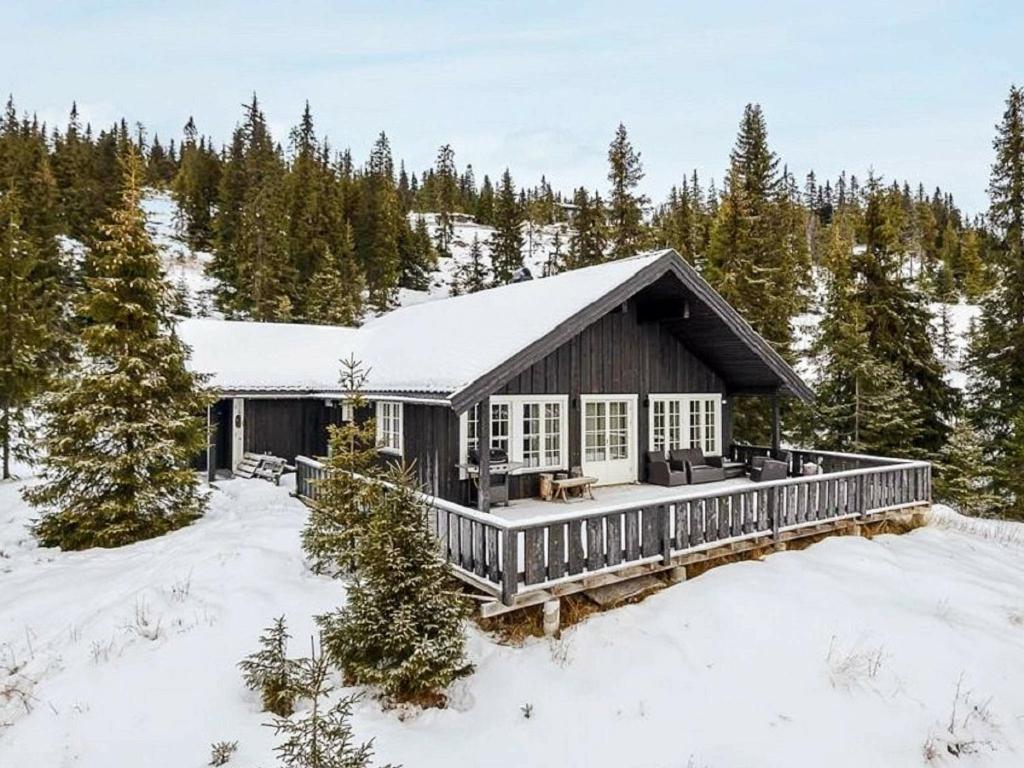 a house with a deck in the snow at 11 person holiday home in F vang in Favang