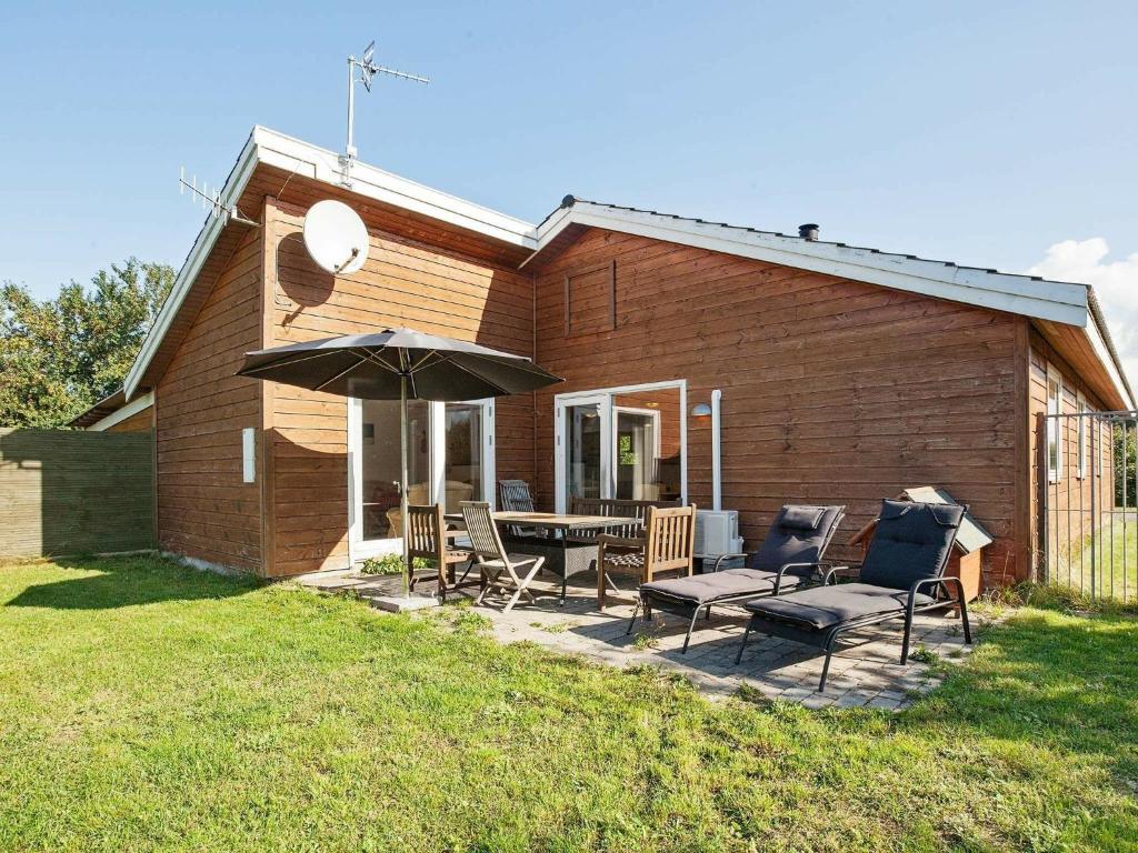 Asnæsにある6 person holiday home in Asn sのパティオ(テーブル、椅子、パラソル付)