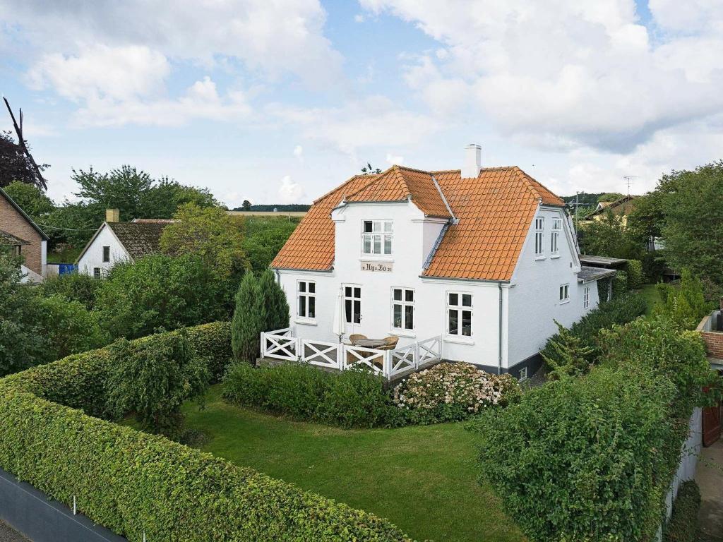スヴァネケにある6 person holiday home in Svanekeのオレンジ色の屋根の白い家