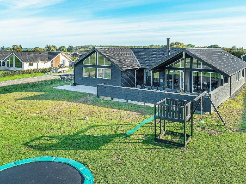 une maison avec une aire de jeux en face dans l'établissement 14 person holiday home in Bogense, à Bogense