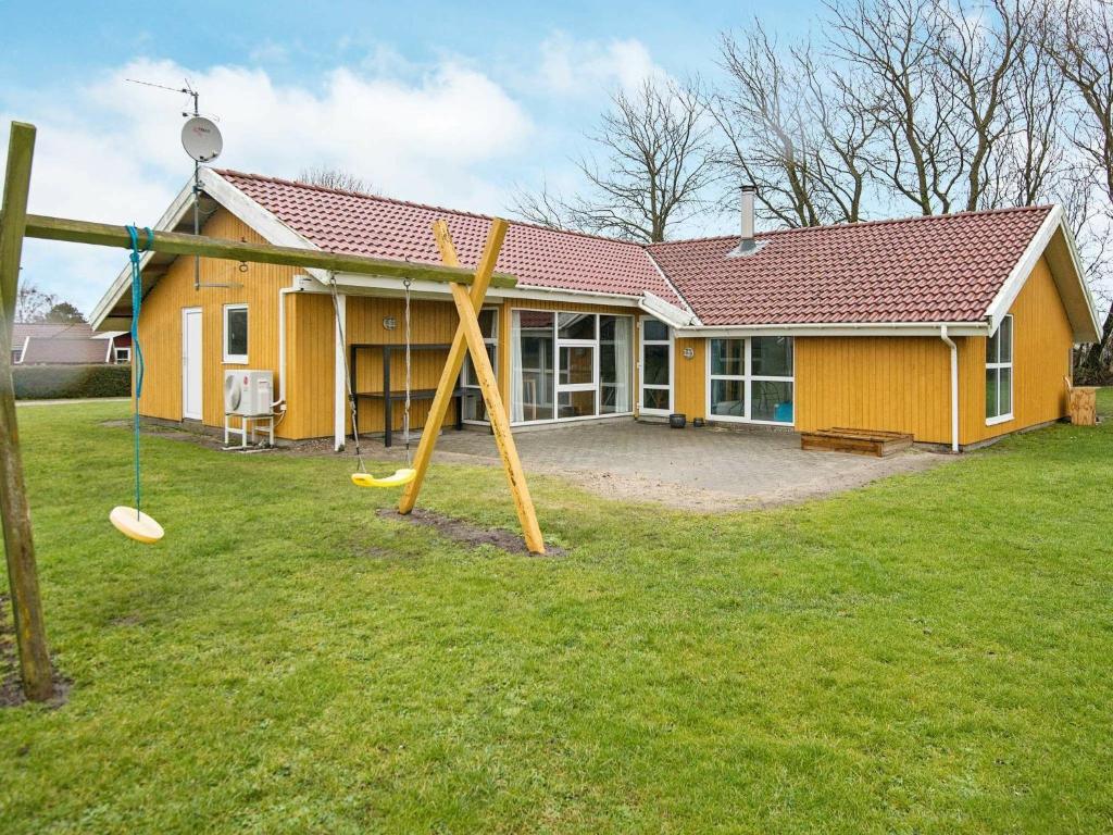 ノーポにある12 person holiday home in Nordborgの庭遊び場付黄色の家
