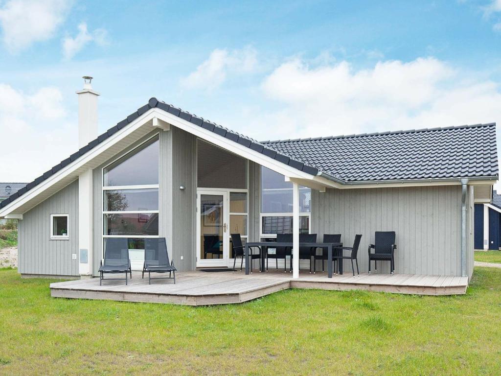 グローセンブローデにある8 person holiday home in Gro enbrodeのデッキ(テーブル、椅子付)が備わる家