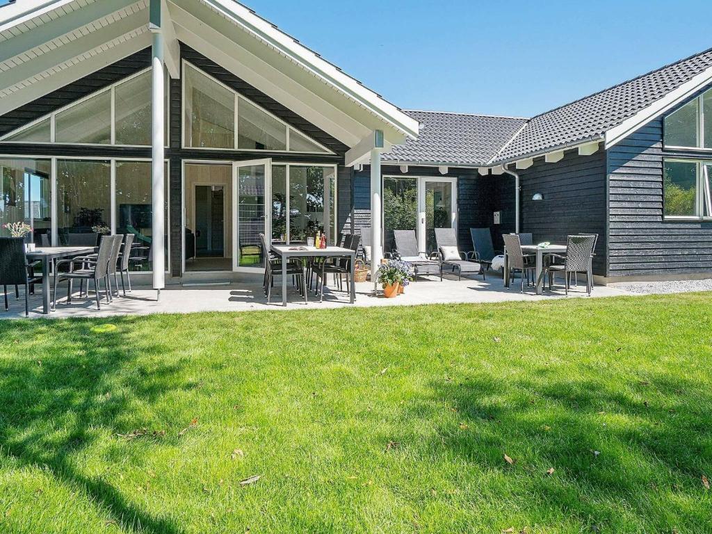 a patio with tables and chairs on a house at 18 person holiday home in Hasselberg in Kappeln