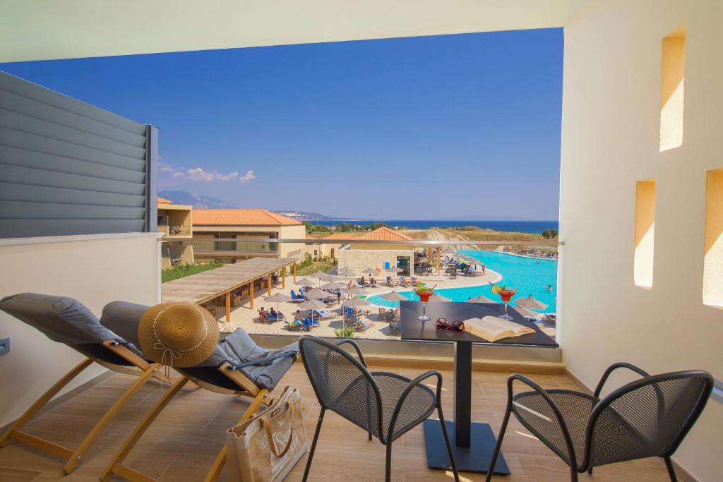 balcone con vista sulla piscina di un resort di Apollonion Asterias Resort and Spa a Xi