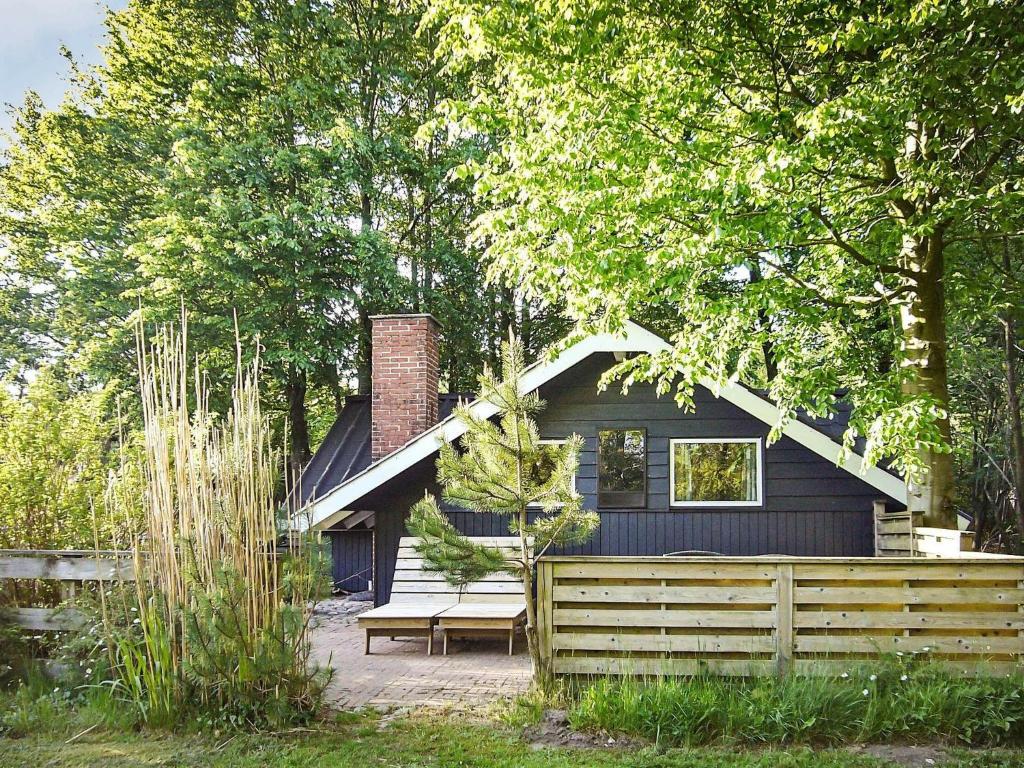 een zwart huis met een bankje ervoor bij 6 person holiday home in Toftlund in Arrild