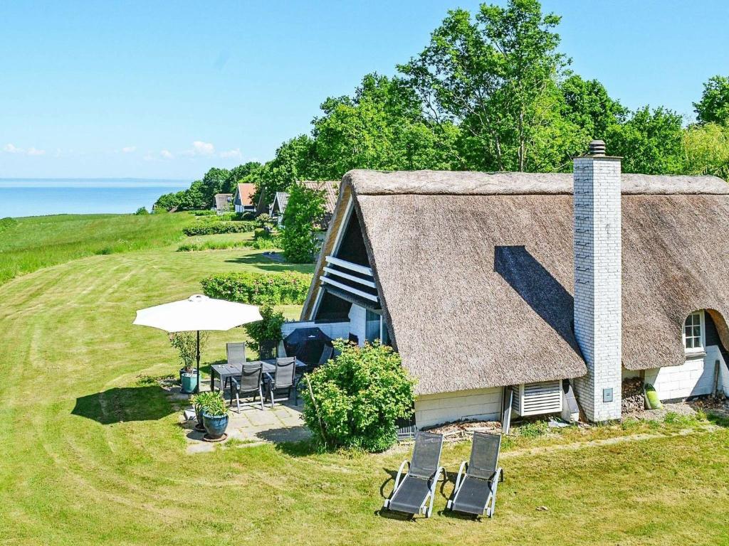 an aerial view of a house with chairs and an umbrella at 6 person holiday home in Asperup in Asperup