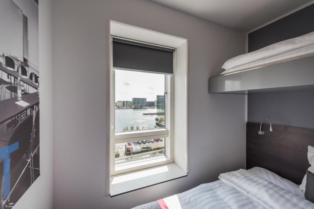 a bedroom with a window with a view of the water at Cabinn Copenhagen in Copenhagen