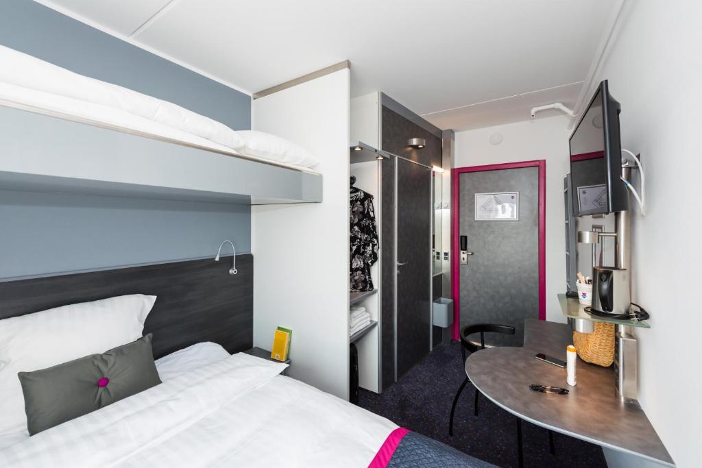 a bedroom with a bed and a desk in a room at Cabinn Copenhagen in Copenhagen