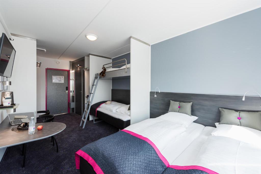 a hotel room with a bed and a desk and a bunk bed at Cabinn Copenhagen in Copenhagen