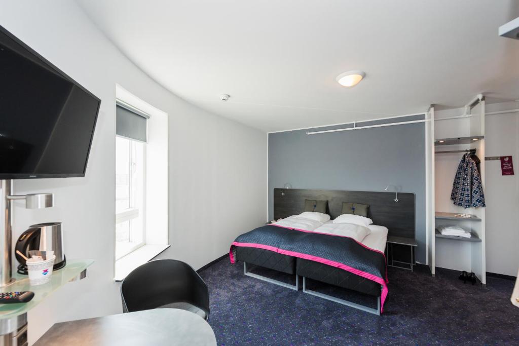 a bedroom with a bed with a large mirror at Cabinn Copenhagen in Copenhagen