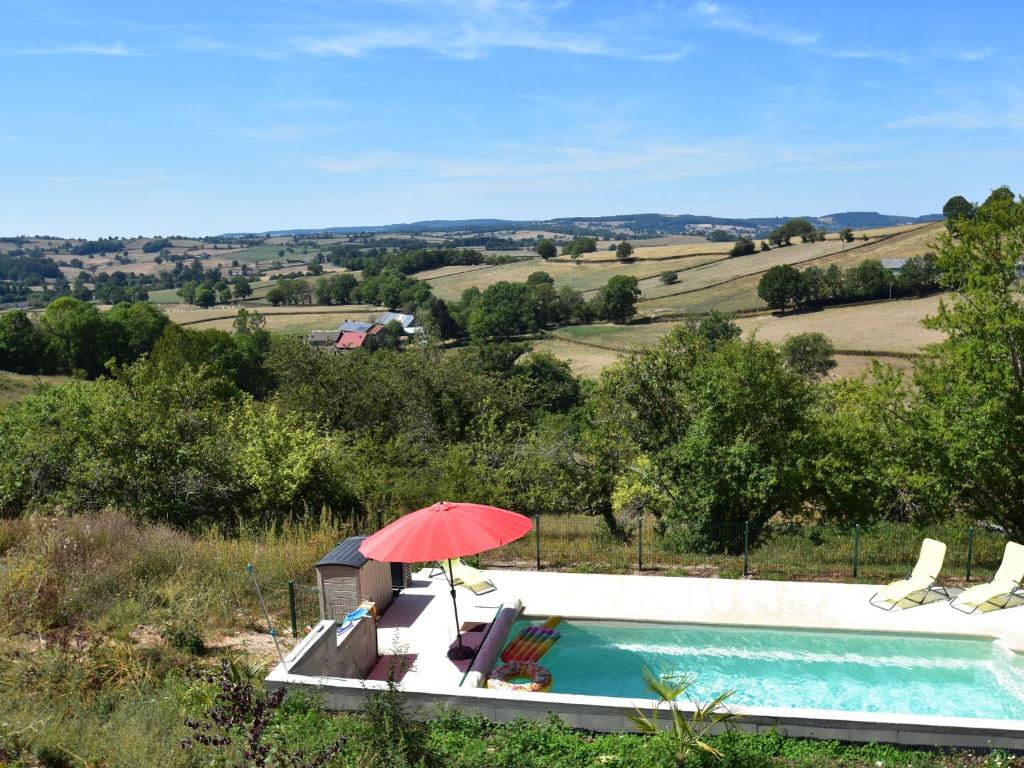 a red umbrella sitting next to a swimming pool at Modern apartment in Cuzy with shared pool in Cuzy