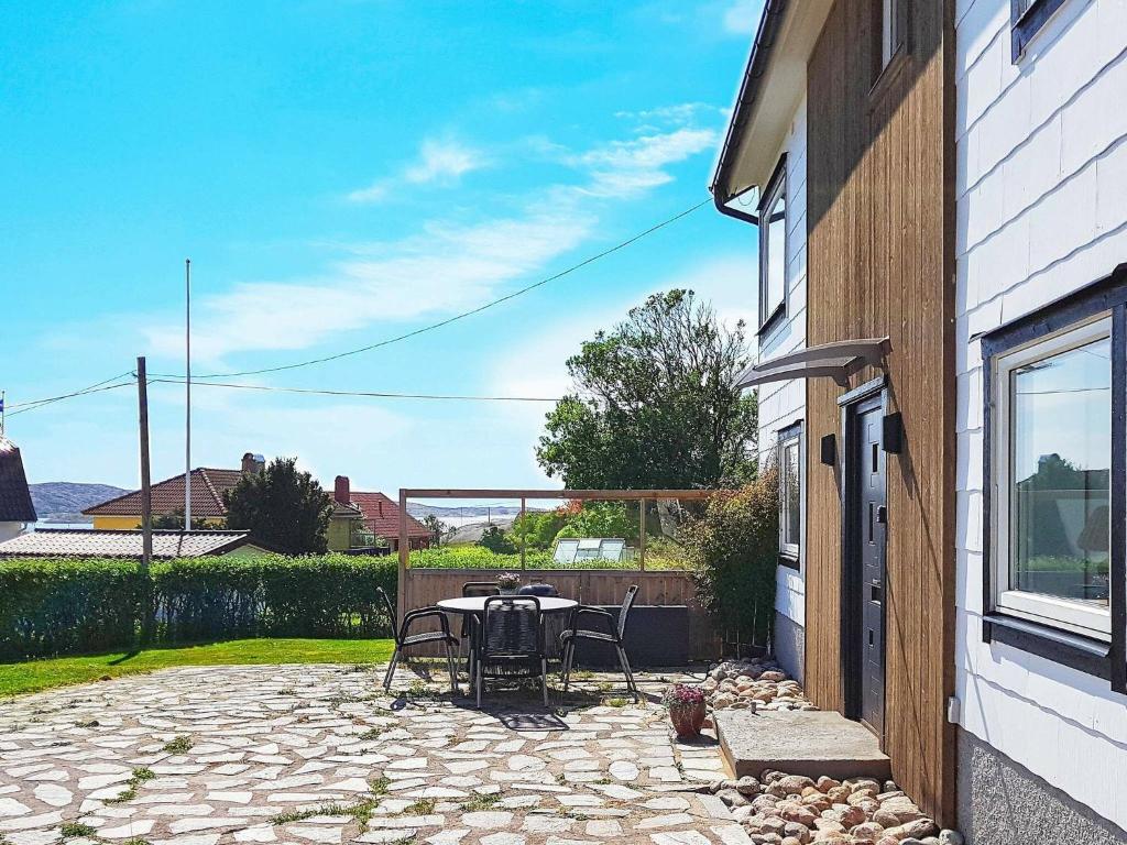 um pátio com uma mesa e cadeiras ao lado de um edifício em 4 person holiday home in H LLEVIKSSTRAND em Hälleviksstrand