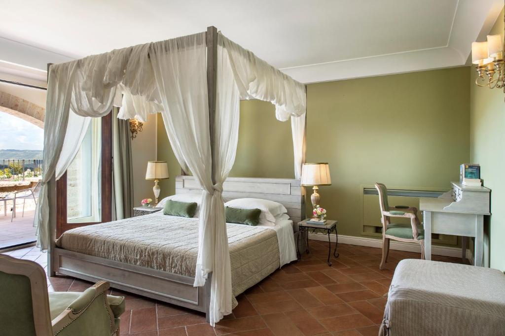 a bedroom with a large bed and a large window at Altarocca Wine Resort Adults Only in Orvieto