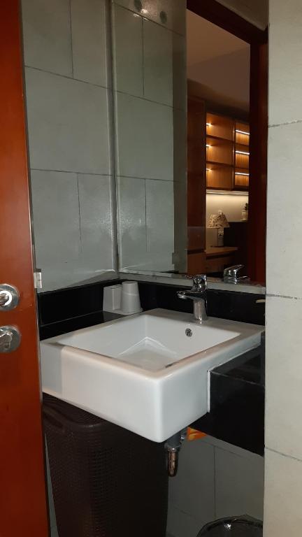 een witte wastafel in een badkamer met een spiegel bij Studio Suite Roseville @ BSD City, Great Location in Tangerang