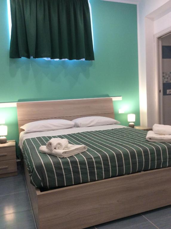 賈迪尼－納克索斯的住宿－Naxos Laguna Beach，一间卧室配有一张床,床上有毛巾