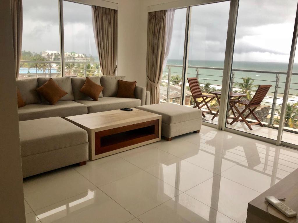 
a living room filled with furniture and a view of the ocean at Prime Wave Residence in Mount Lavinia
