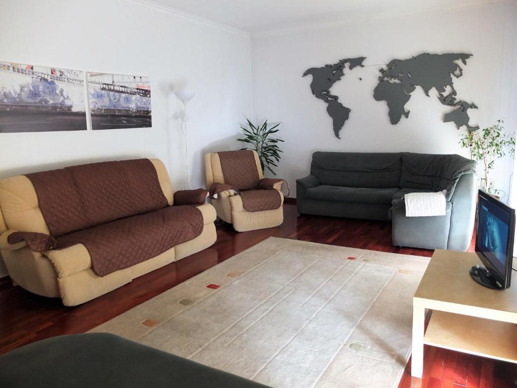 a living room with two couches and a world map on the wall at House near Fontelo in Viseu