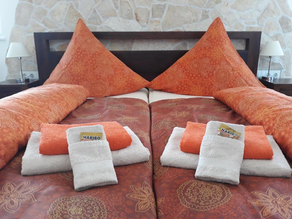 a bed with orange and white towels on it at Gästehaus Wohngut Eisenach in Eisenach