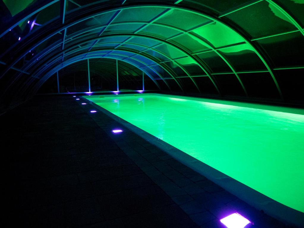 a swimming pool with green lighting in a tunnel at Radawa - Domki przy Stadninie in Radawa