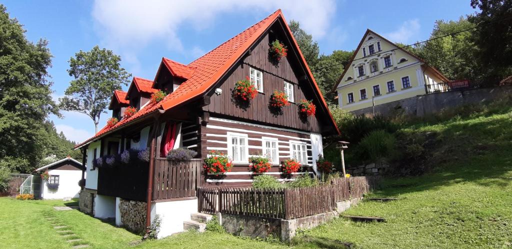 a house with flower boxes on the front of it at Chalupa U Studánky in Adršpach