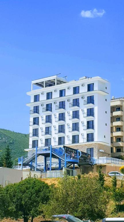 un grande edificio bianco con un ponte blu davanti di Hotel Svarog a Bečići