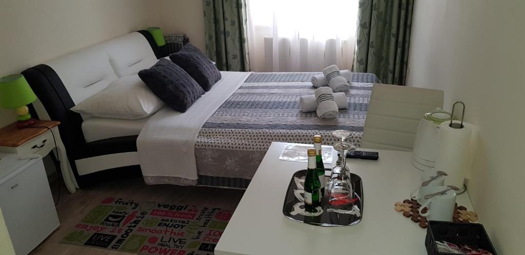 1 dormitorio con 1 cama y 1 mesa con botellas de vino en ELG Rooms en Postojna