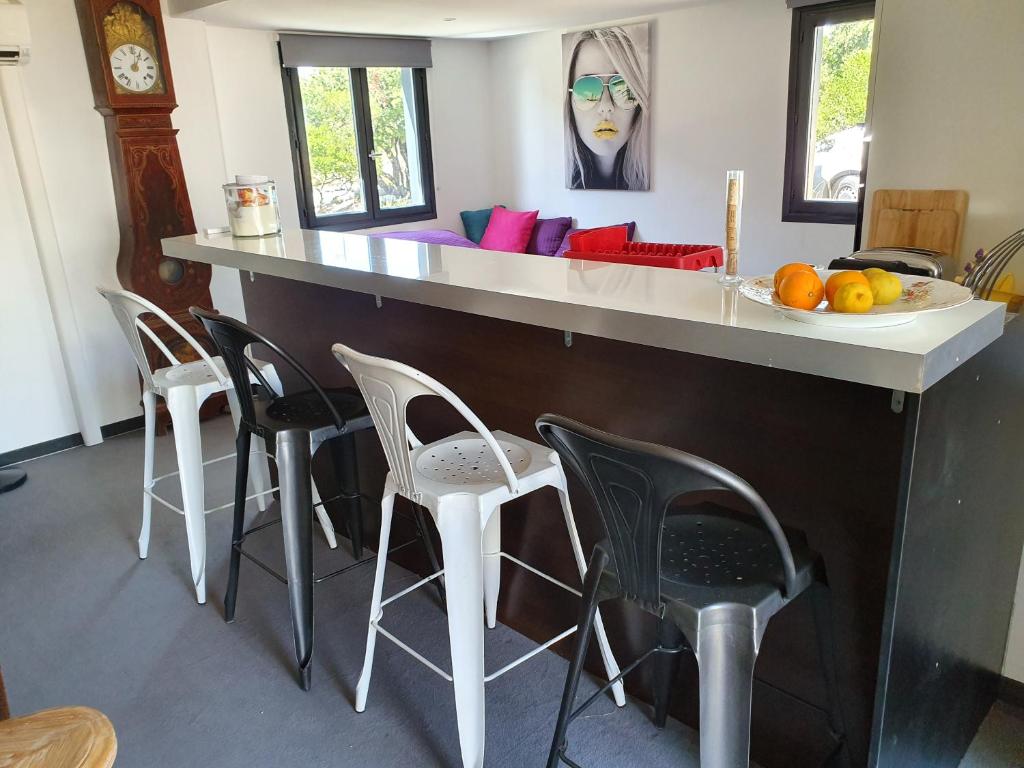 - une cuisine avec un bar avec des chaises et un canapé dans l'établissement LOFT 3 PERS PROCHE CIRCUIT PAUL RICARD, à Signes