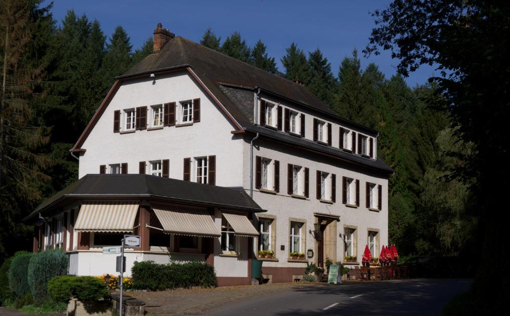 un grand bâtiment blanc avec un toit noir dans l'établissement Hostellerie de la Vallée, à Heffingen