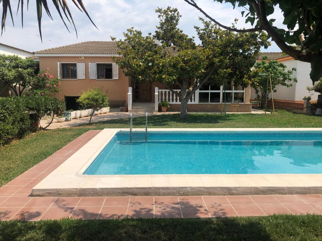 a swimming pool in front of a house at Chalet con piscina privada en Vinaròs in Vinarós