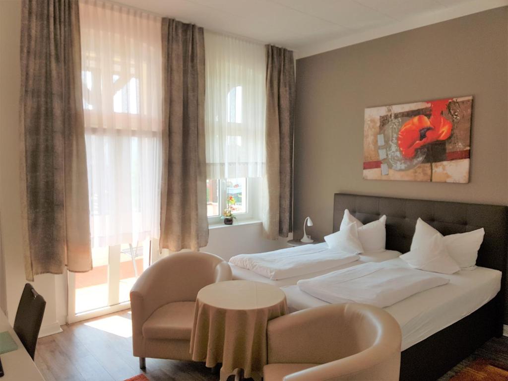 pokój hotelowy z łóżkiem, stołem i krzesłami w obiekcie Villa zur schönen Aussicht w mieście Bad Salzuflen