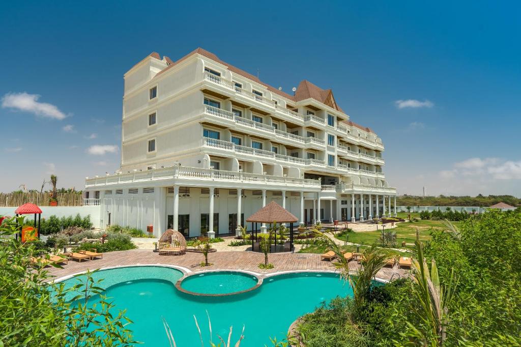 a large white building with a pool in front of it at The Fern Sattva Resort, Dwarka in Dwarka