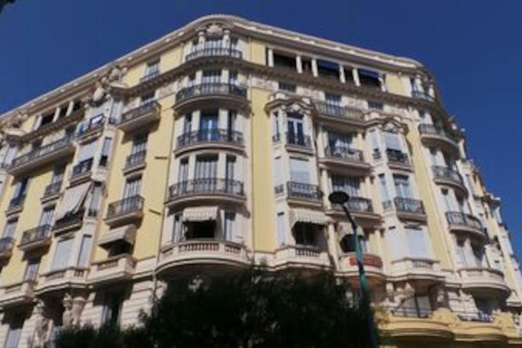 un bâtiment jaune avec des balcons sur son côté dans l'établissement Studio Astoria, à Menton