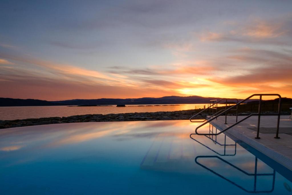 a swimming pool with a sunset in the background at Portavadie Loch Fyne Scotland in Portavadie