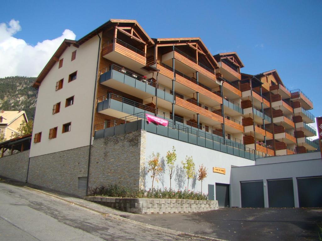 a large white building with balconies on the side of it at Mar Mar Appartaments in Briançon