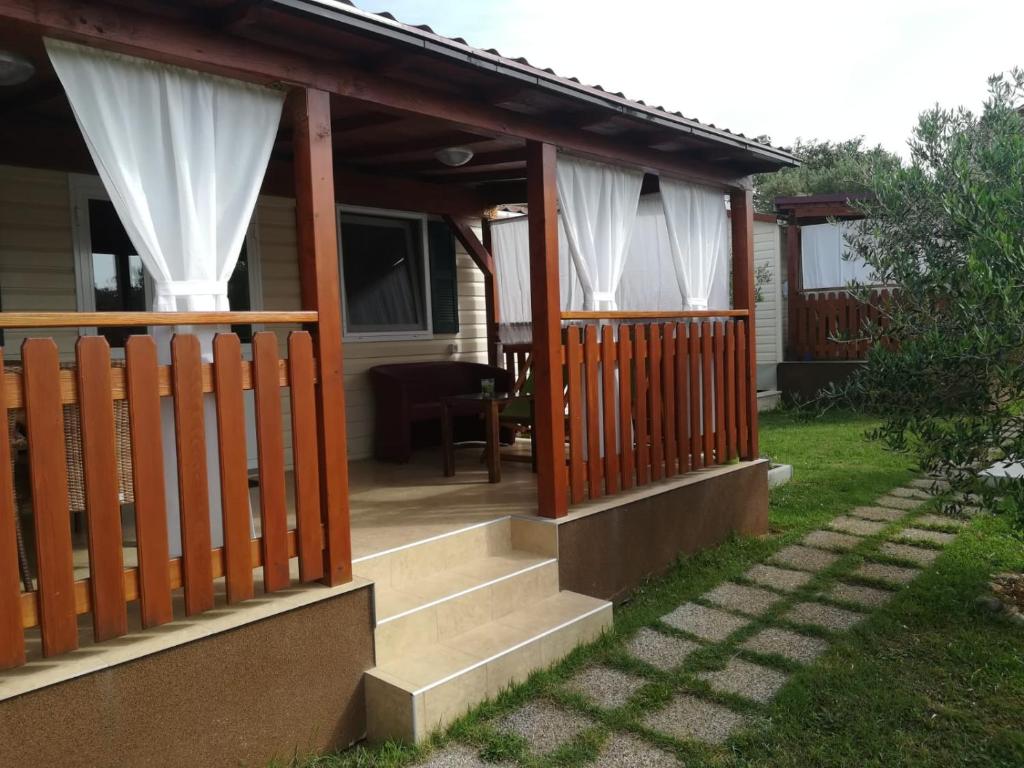 uma casa com um alpendre com cortinas brancas em Mobile House Danijel em Sveti Filip i Jakov