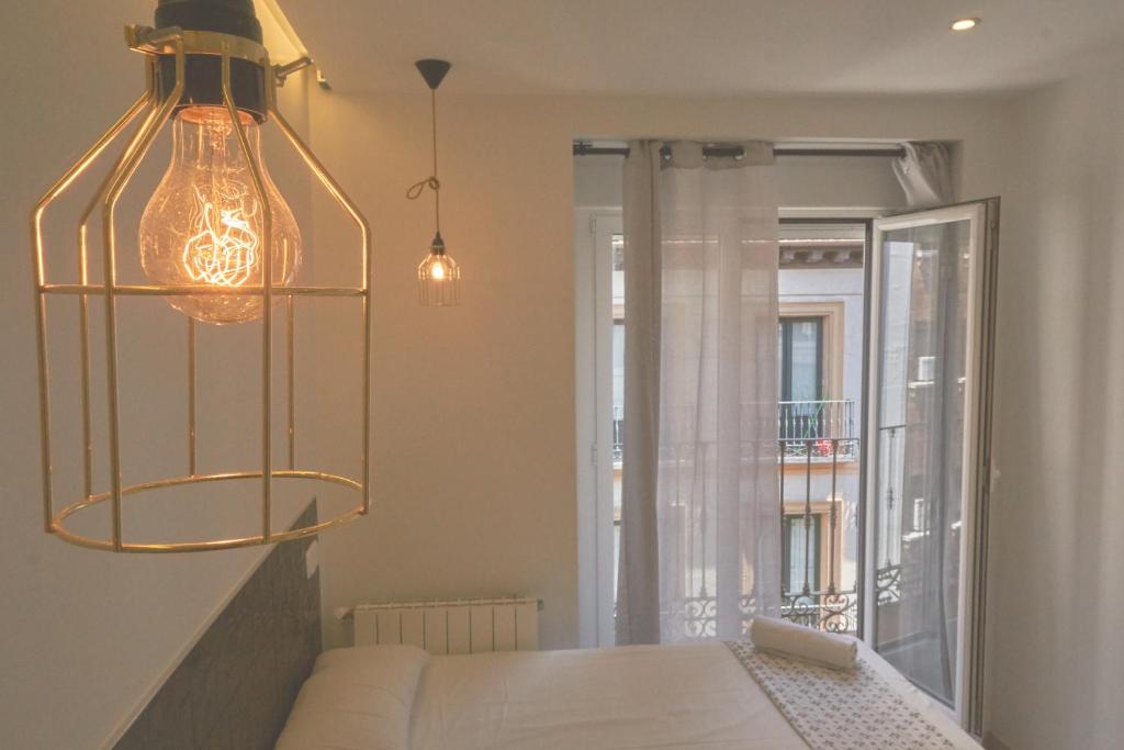 Madrid Gran Vía, Behap Apartments في مدريد: غرفة معيشة مع أريكة وثريا