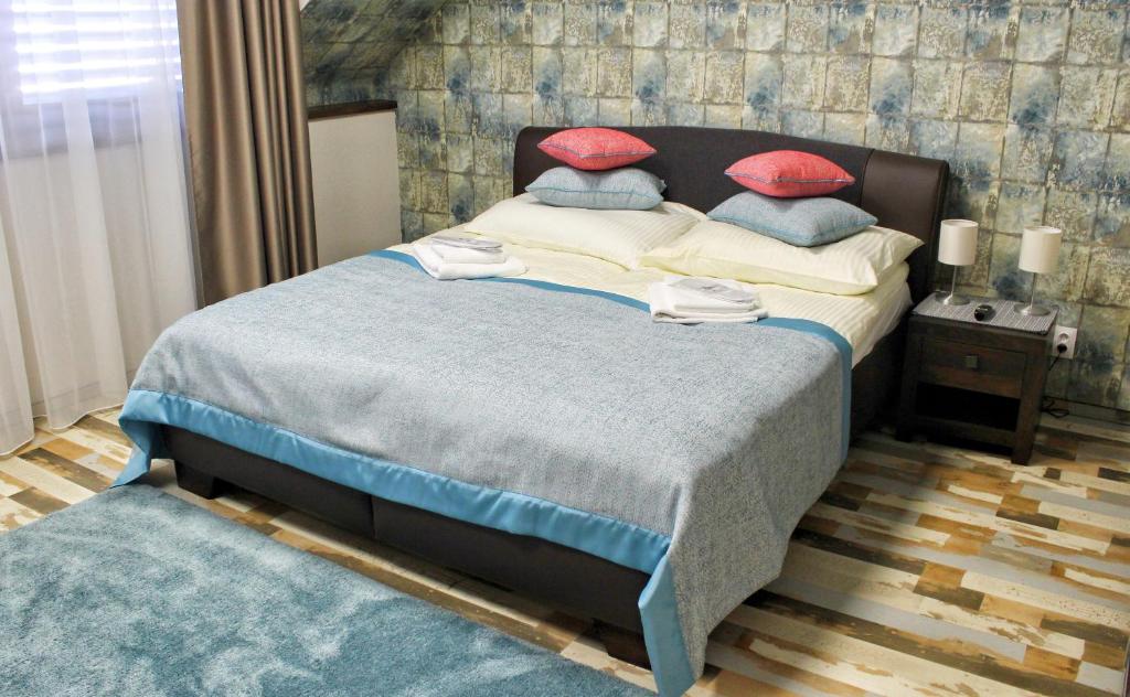 um quarto com uma cama com almofadas vermelhas e azuis em Quad room in Apartments 461, room No. 9 em Modřice