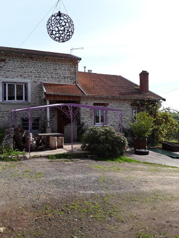 una casa con un cenador púrpura delante de ella en Gîte, en Montagny-sur-Grosne