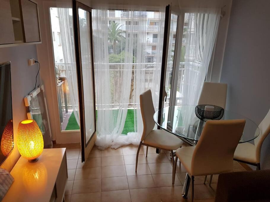 ein Wohnzimmer mit einem Glastisch und Stühlen in der Unterkunft Apartamento excepcional,piscina y 100m de la playa, parking gratis!! in Salou