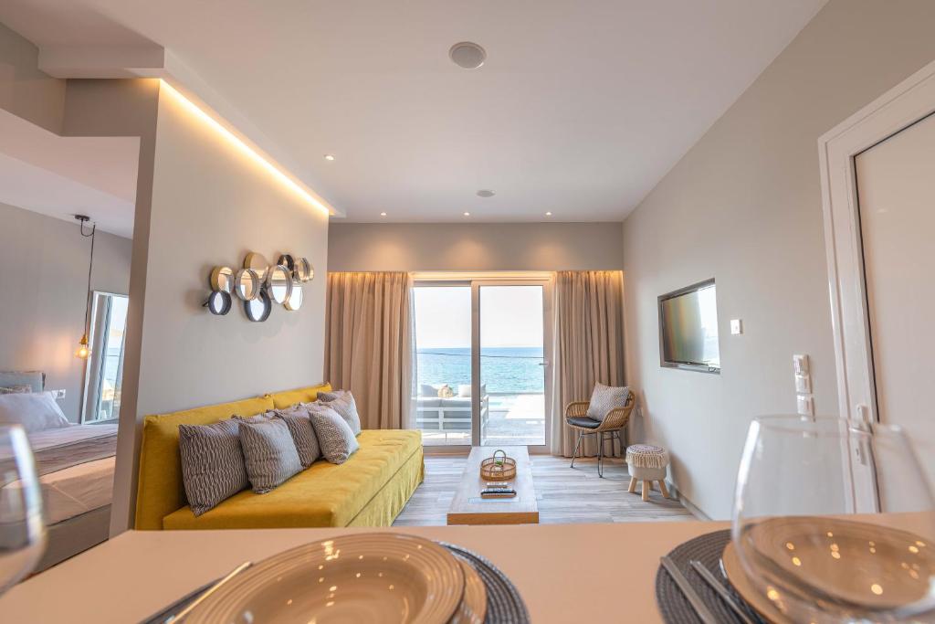 a living room with a yellow couch and a view of the ocean at Valtes Luxurious Apartments in Mpoukaris