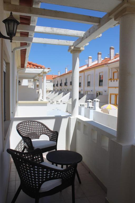 a patio with two chairs and a table on a balcony at Baleal Holiday House in Baleal