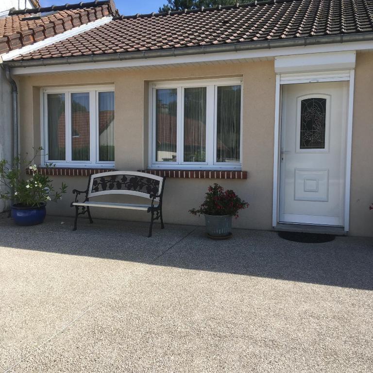 un banc installé sur la terrasse couverte avant d'une maison dans l'établissement Baie de somme, à Pendé