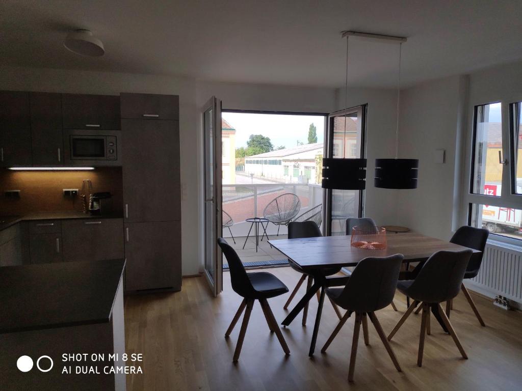 - une cuisine et une salle à manger avec une table et des chaises dans l'établissement City Appartement Wien-Schwechat, à Schwechat