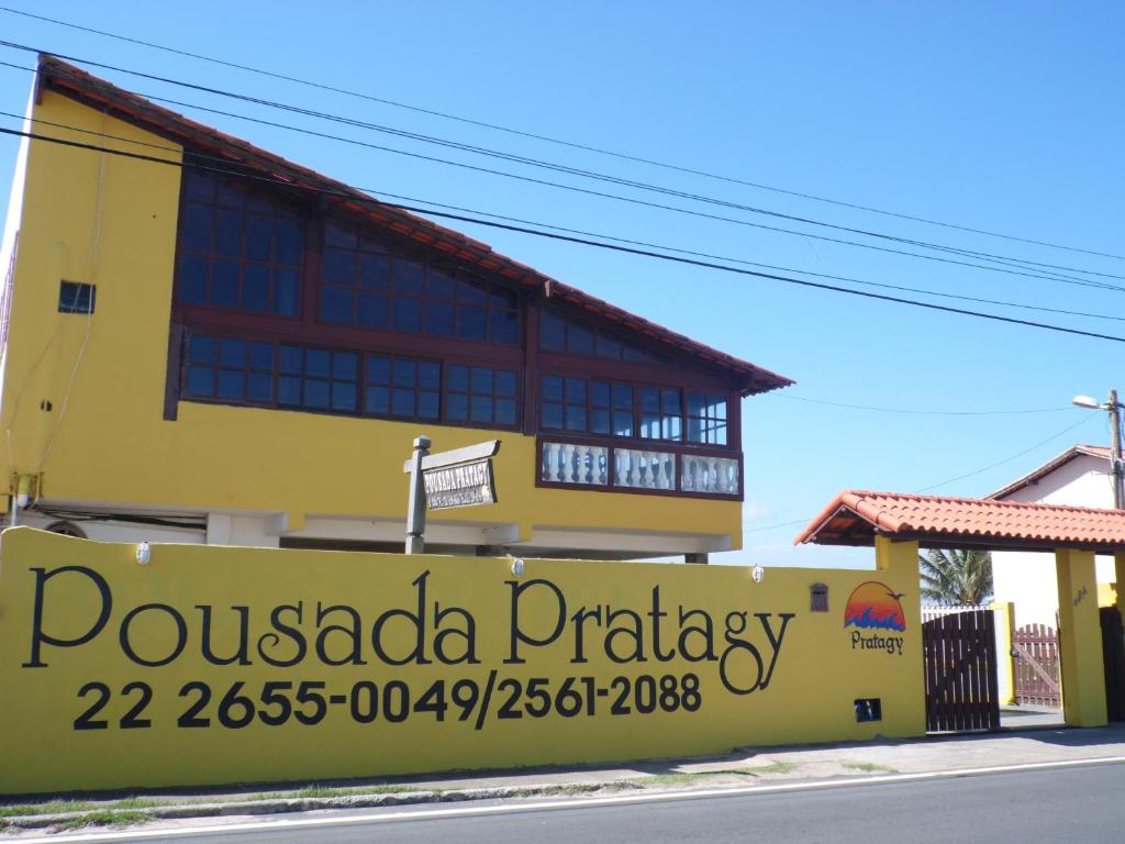 um edifício amarelo com um sinal que lê pirataria pucada em Pousada Pratagy em Saquarema