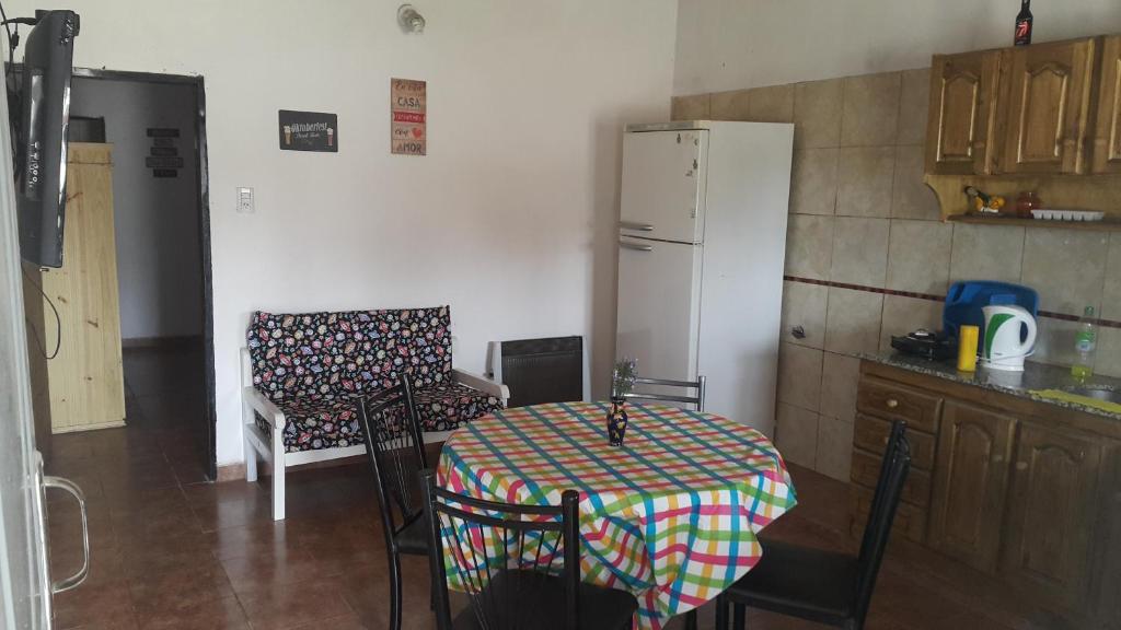 Departamentos ramallo في رامالو: مطبخ مع طاولة وثلاجة بيضاء